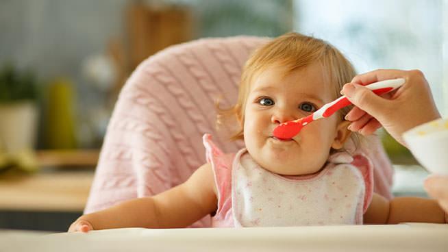 Bebé feliz explorando alimentos